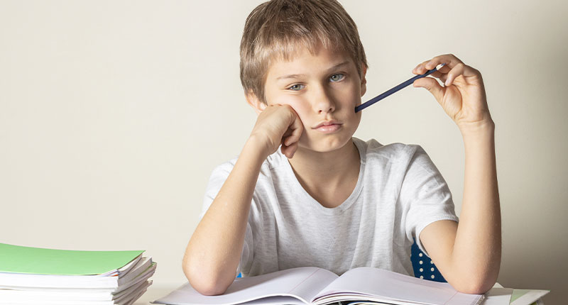 Bambino pensierorso davanti a un libro aperto